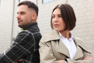 Photo of Man and woman turned away from each other outdoors. Relationship problems