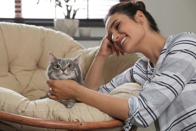 Photo of Young woman with cute cat at home. Pet and owner