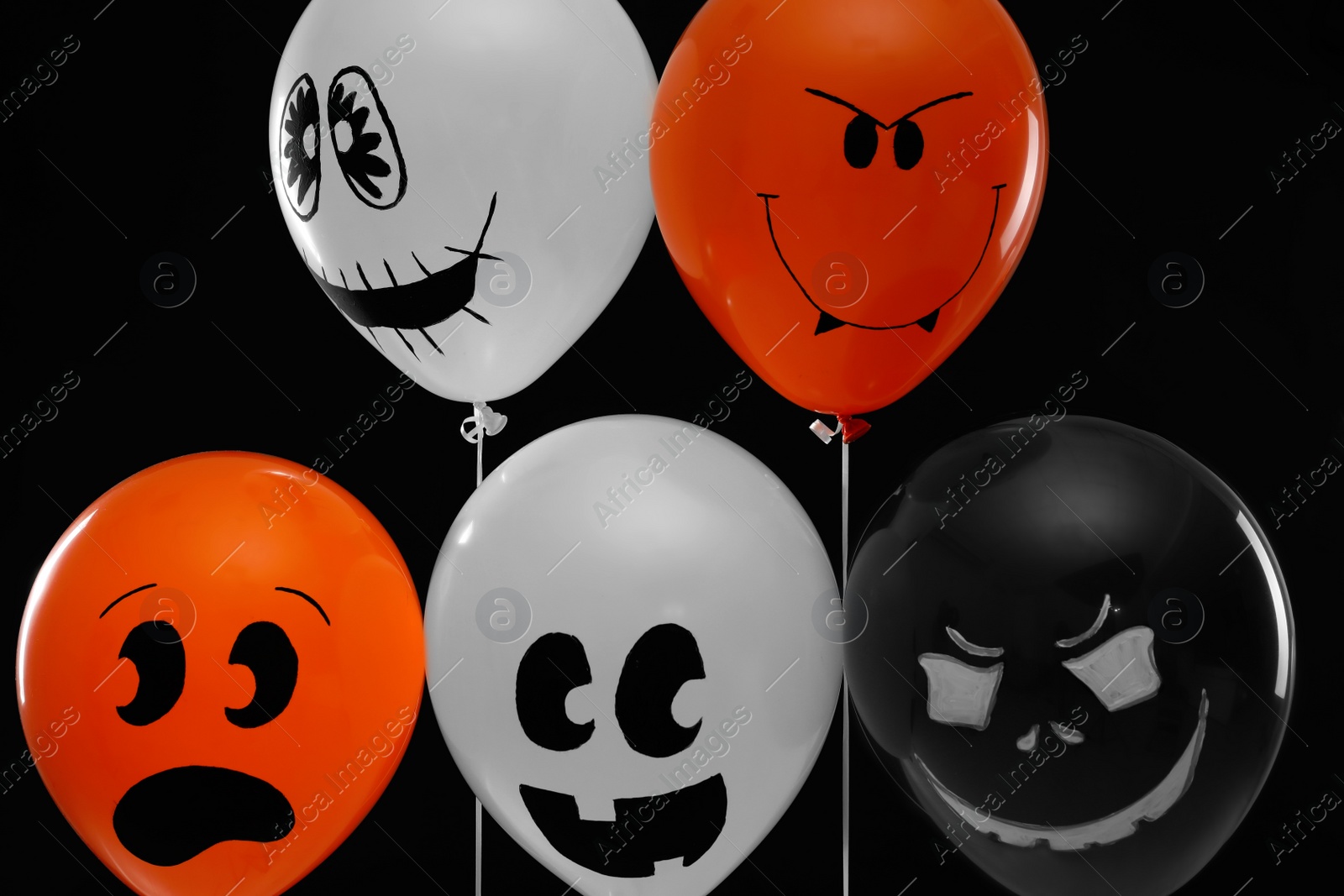 Photo of Spooky balloons for Halloween party on black background
