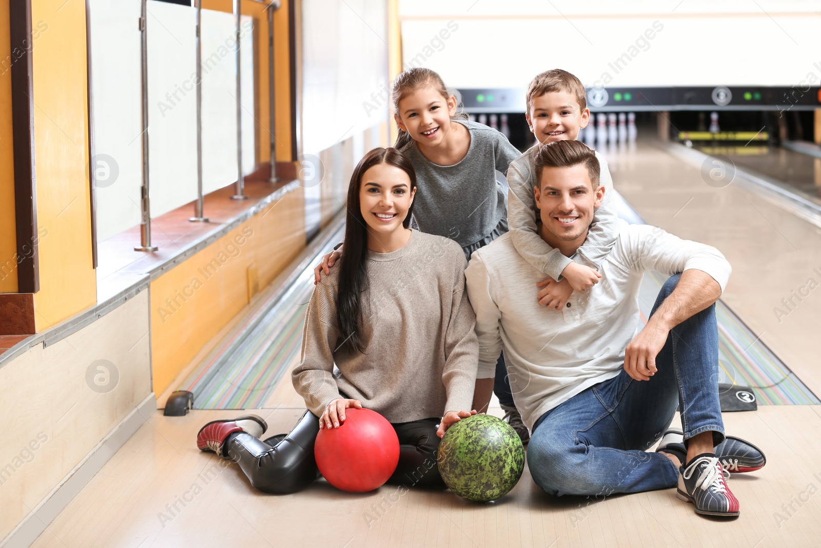 Photo of Happy family spending time together in bowling club