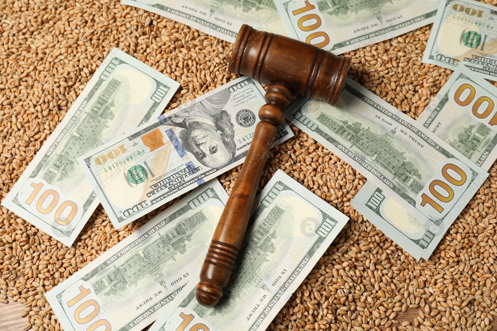 Photo of Dollar banknotes, wooden gavel and wheat grains on table, top view. Agricultural business