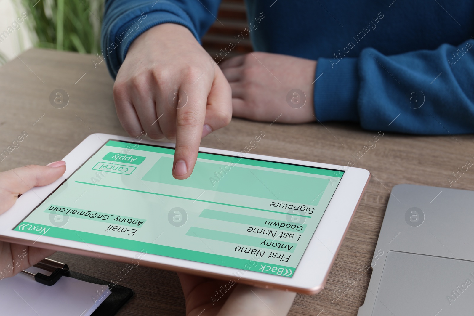 Image of Electronic signature. Man using tablet at wooden table, closeup