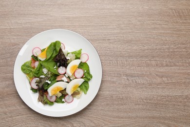 Photo of Delicious salad with boiled egg, radish and cheese on wooden table, top view. Space for text