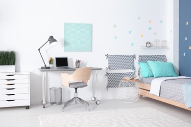 Modern child room interior with comfortable bed and desk