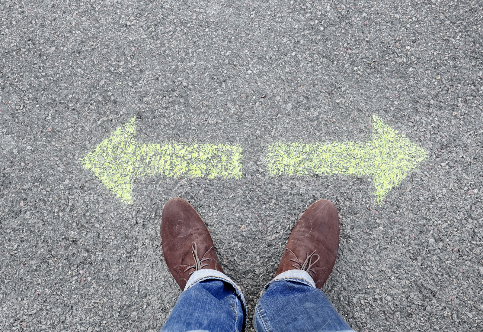 Photo of Man standing on road near arrows marking, closeup