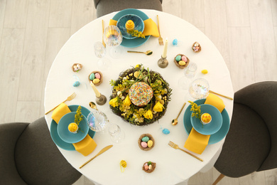 Photo of Festive Easter table setting with beautiful floral decor and eggs, top view