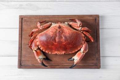 Photo of Delicious boiled crab on white wooden table, top view
