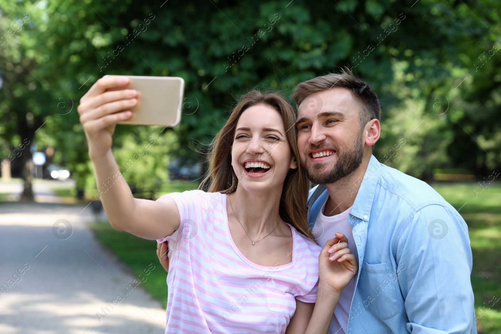 Photo of Happy young couple taking selfie in park