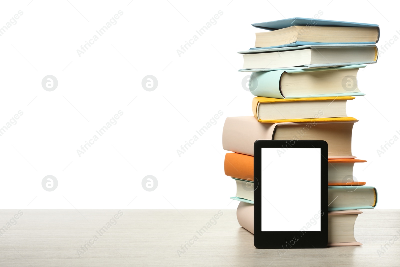 Photo of Stack of hardcover books and modern e-book on wooden table against white background. Space for text