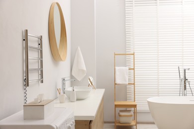 Photo of Stylish bathroom interior with heated towel rail and vanity