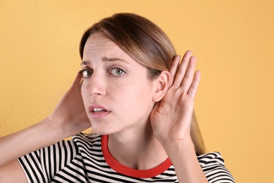 Photo of Young woman with hearing problem on color background