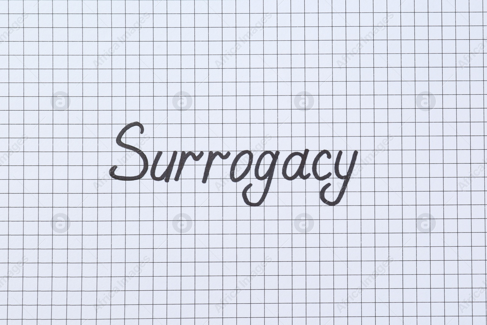 Photo of Word Surrogacy written on checkered paper, top view