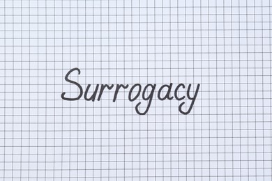 Photo of Word Surrogacy written on checkered paper, top view
