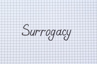 Word Surrogacy written on checkered paper, top view