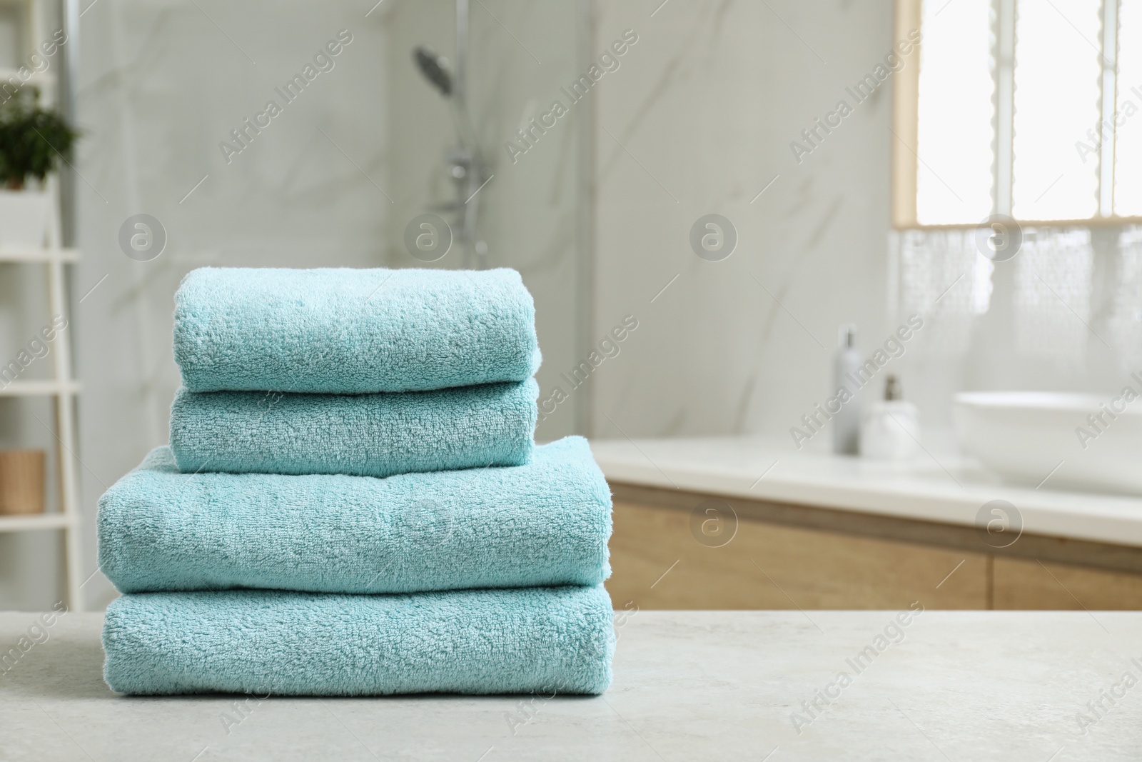 Photo of Stack of clean towels on table indoors. Space for text