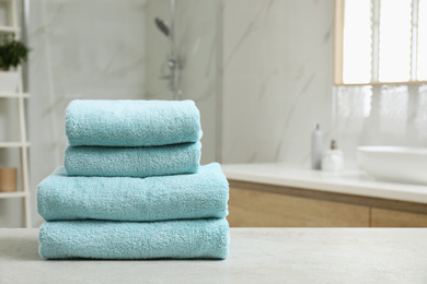 Photo of Stack of clean towels on table indoors. Space for text