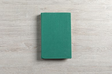 Hardcover book on white wooden table, top view