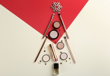 Christmas tree shape of decorative cosmetic products on color background, flat lay. Winter care