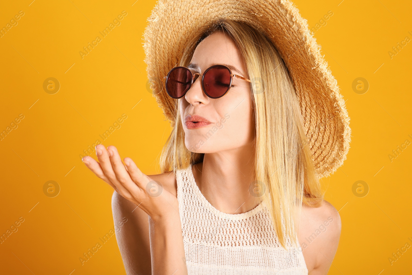 Photo of Beautiful woman in stylish sunglasses on yellow background