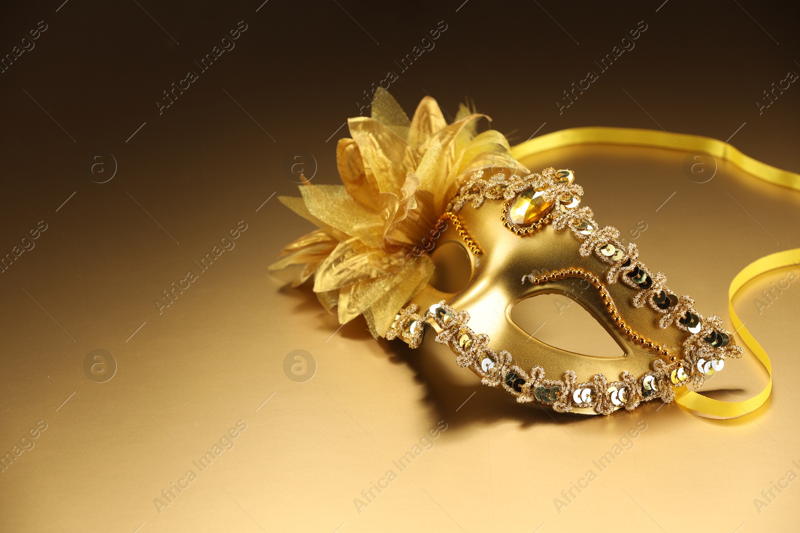 Photo of Beautifully decorated face mask on beige background, space for text. Theatrical performance