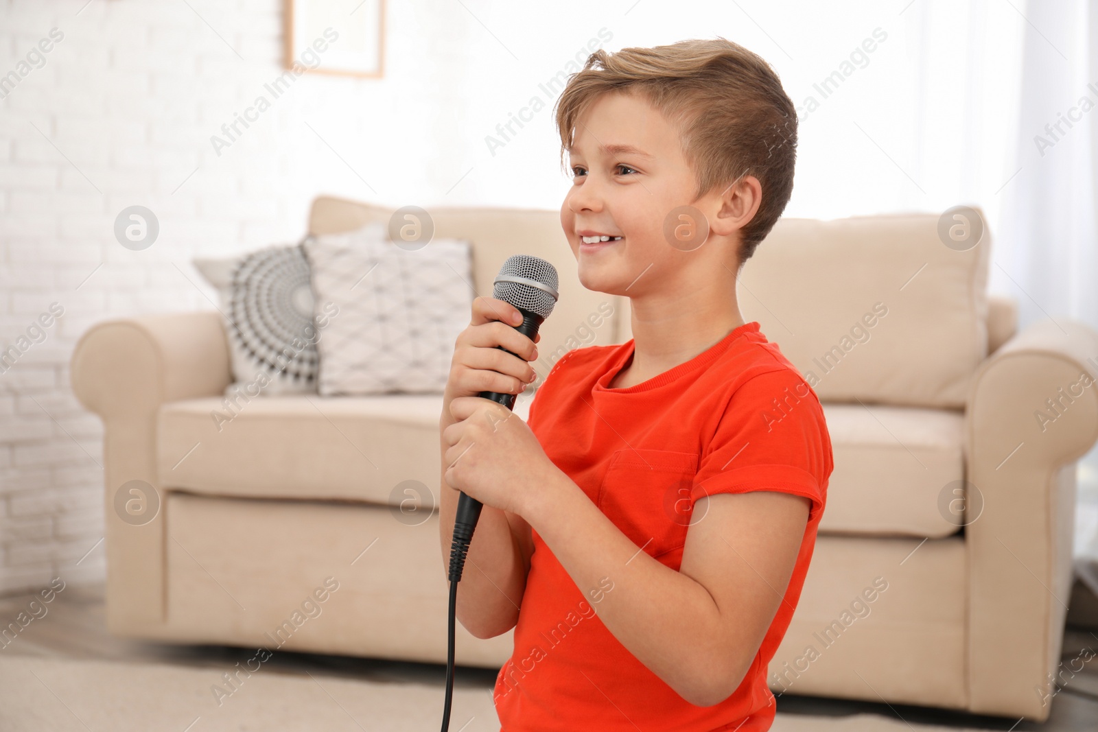Photo of Cute boy with microphone in living room
