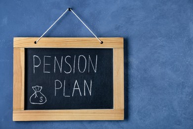 Photo of Chalkboard with phrase Pension Plan hanging on blue wall