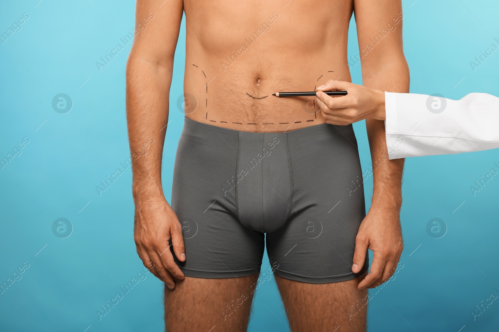 Photo of Doctor with pencil preparing patient for cosmetic surgery operation on light blue background, closeup