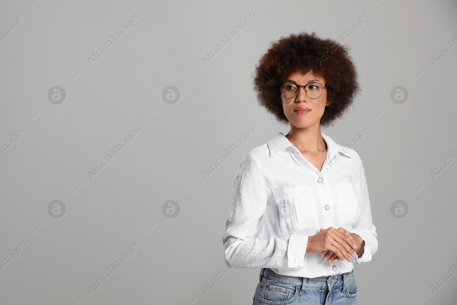 Photo of Beautiful young woman in eyeglasses on grey background. Space for text