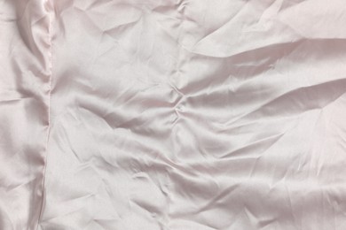 Photo of Crumpled light pink fabric as background, top view