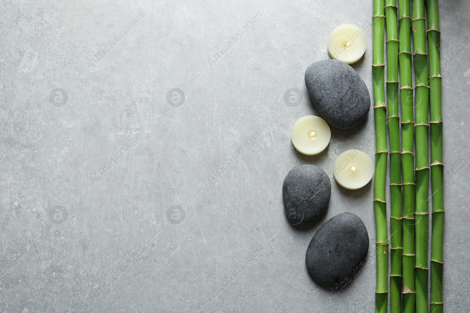 Photo of Flat lay composition with green bamboo stems on grey background. Space for text