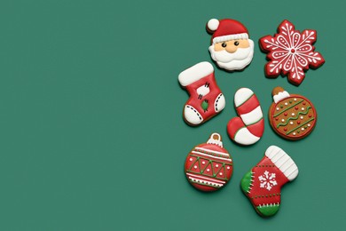 Different tasty Christmas cookies on green background, flat lay. Space for text