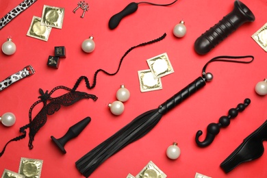 Photo of Different sex toys on red background, flat lay