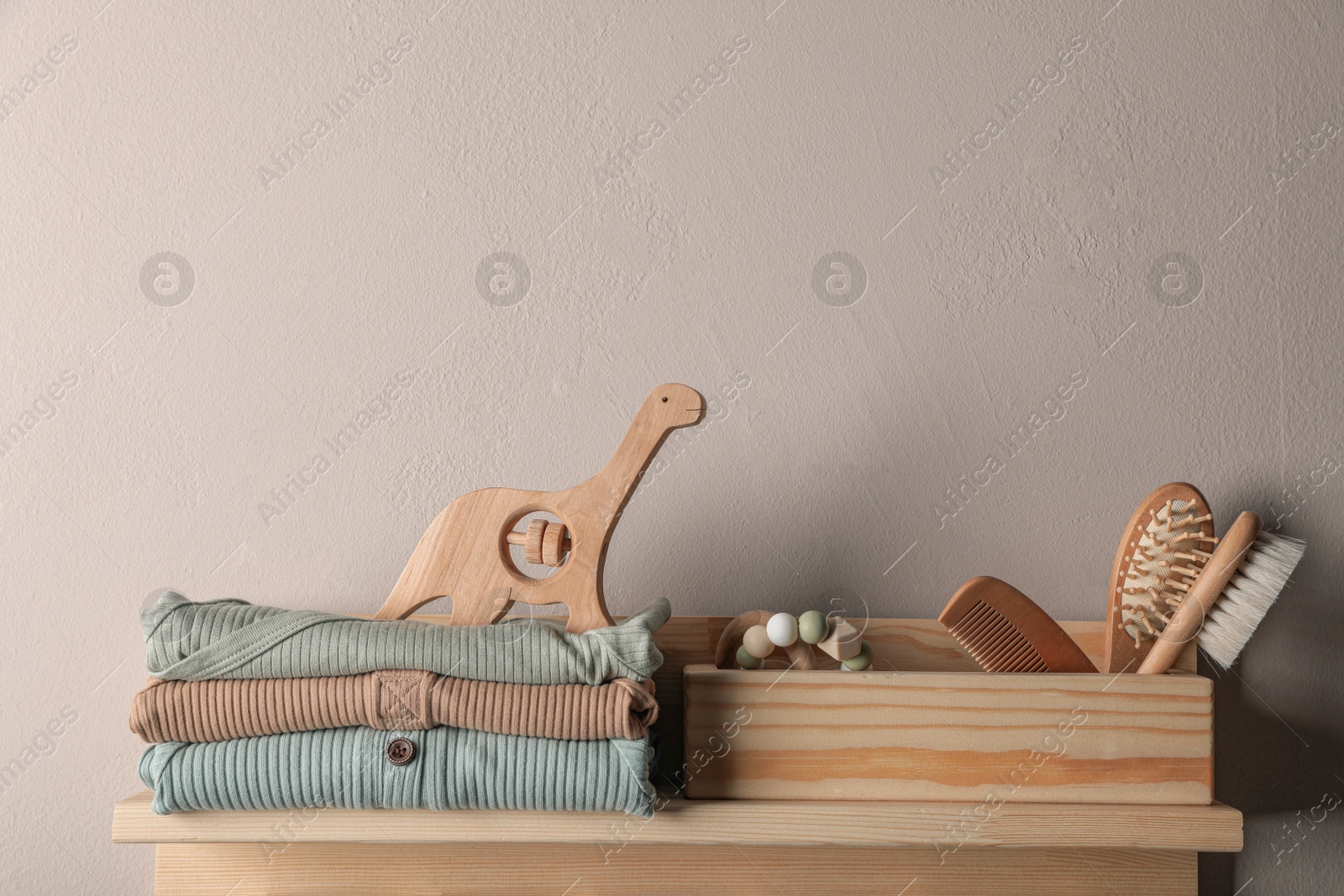 Photo of Baby clothes, toys and accessories on wooden rack