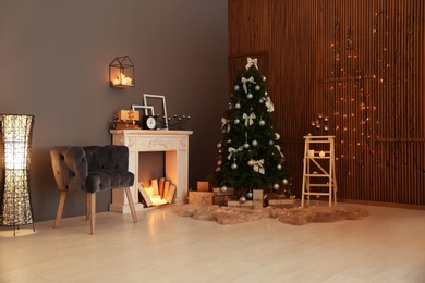 Photo of Stylish room interior with Christmas tree and decorative fireplace