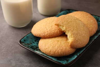 Photo of Delicious Danish butter cookies and milk on grey table, closeup
