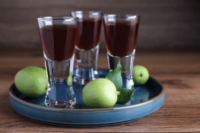 Photo of Delicious liqueur and green walnuts on wooden table