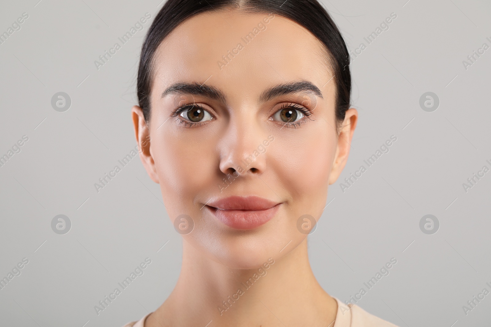 Photo of Portrait of beautiful young woman on grey background