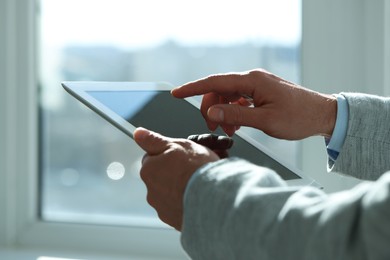 Closeup view of man using new tablet indoors