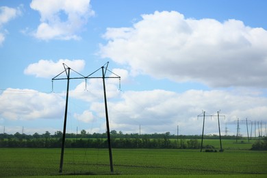 Photo of Telephone poles with cables in field under clear sky