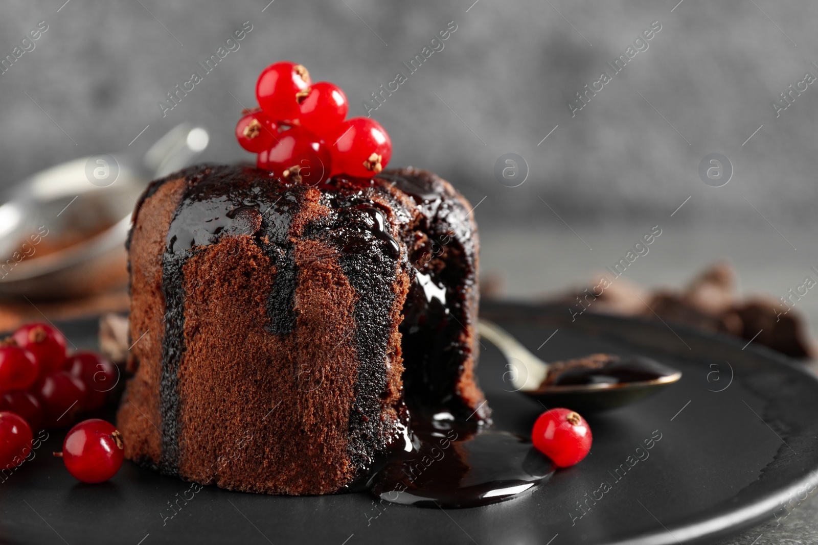 Photo of Delicious warm chocolate lava cake with berries on plate, closeup