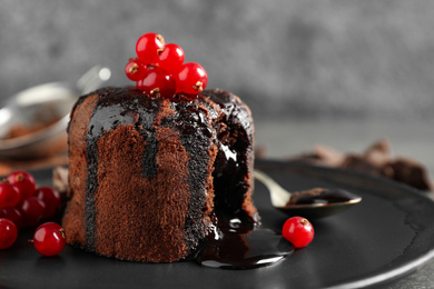 Delicious warm chocolate lava cake with berries on plate, closeup