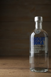 MYKOLAIV, UKRAINE - OCTOBER 03, 2019: Bottle of Absolut vodka on table against wooden background. Space for text