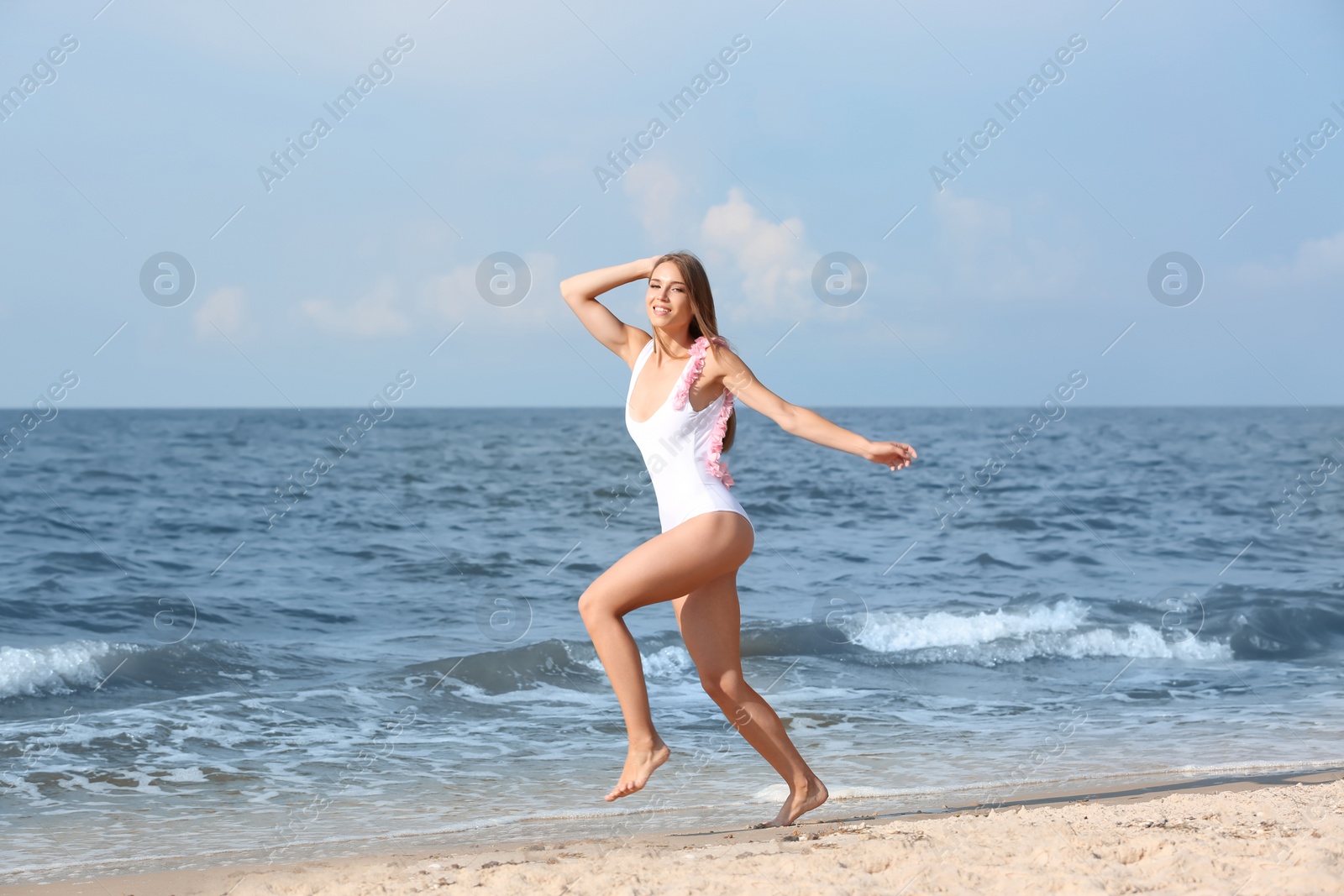 Photo of Attractive young woman in beautiful one-piece swimsuit on beach