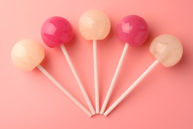 Tasty lollipops on pink background, flat lay