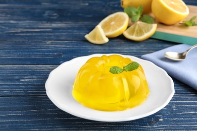Photo of Plate with lemon jelly and mint on blue wooden table