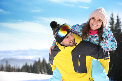 Happy young couple outdoors, space for text. Winter vacation