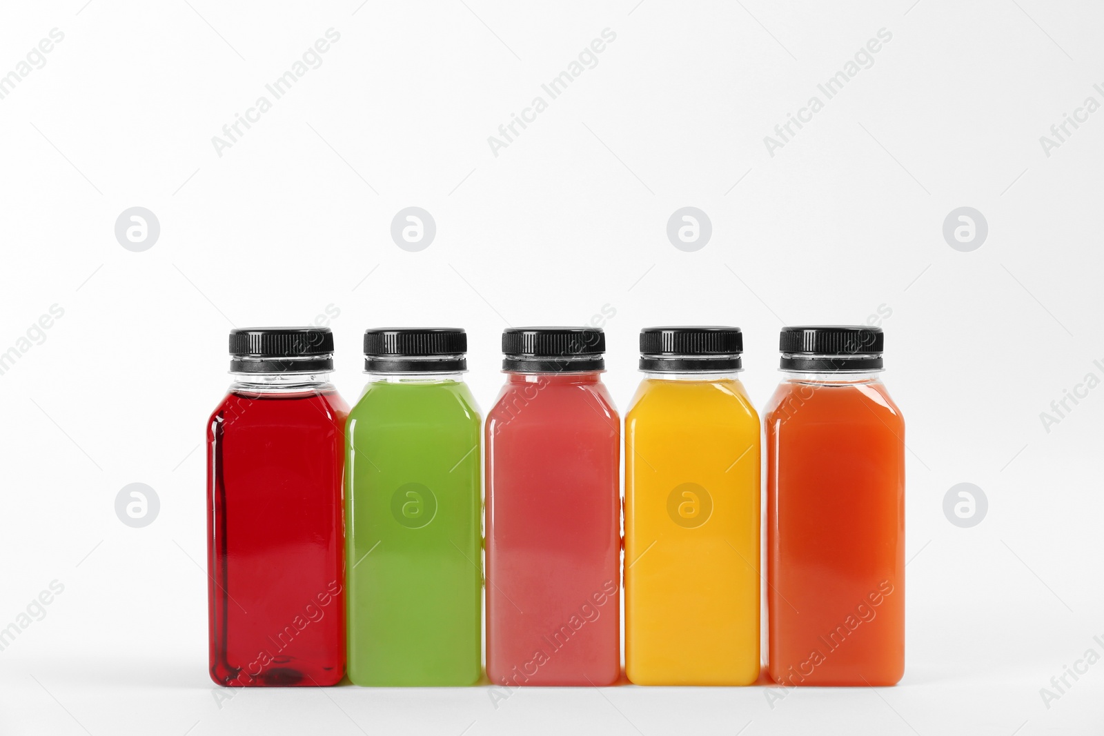 Photo of Bottles with delicious colorful juices on white background