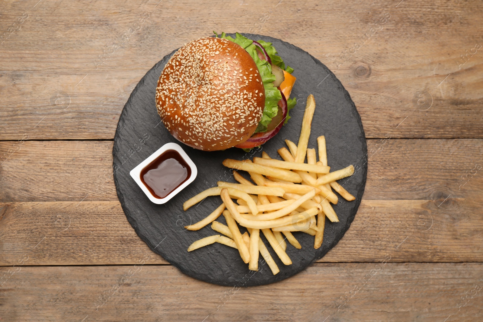 Photo of Burger, French fries and ketchup on wooden table, top view. Fast food