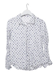 Crumpled polka dot blouse on hanger against white background