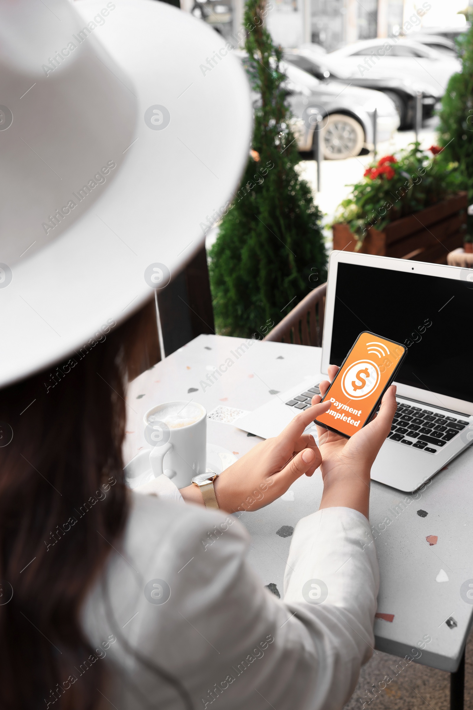 Image of Woman successfully made payment using online banking application on smartphone at outdoor cafe